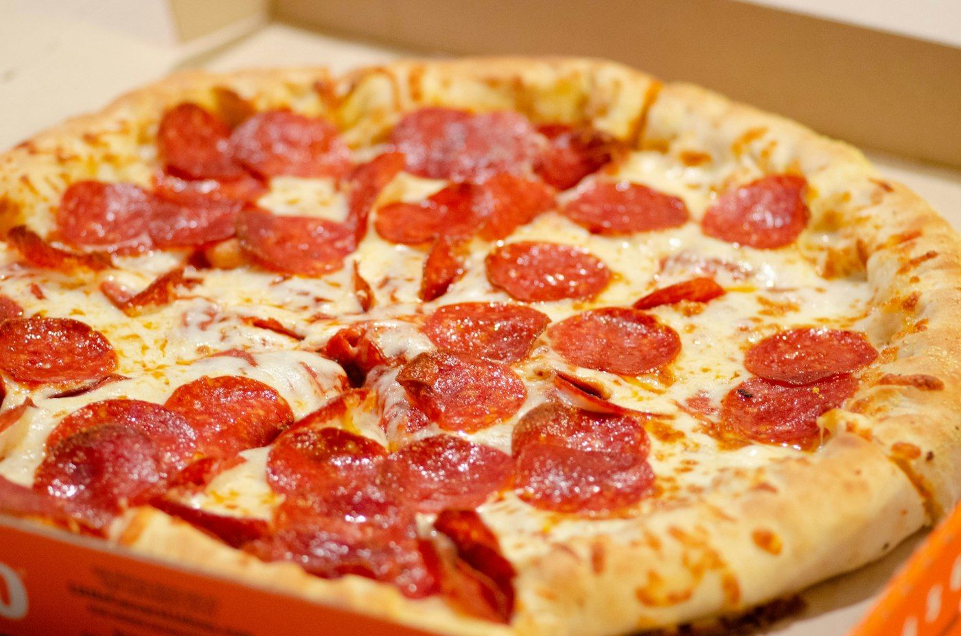 Pizza al salame piccante nel cartone d'asporto